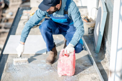 Operaio impermeabilizza la superficie di un terrazzo